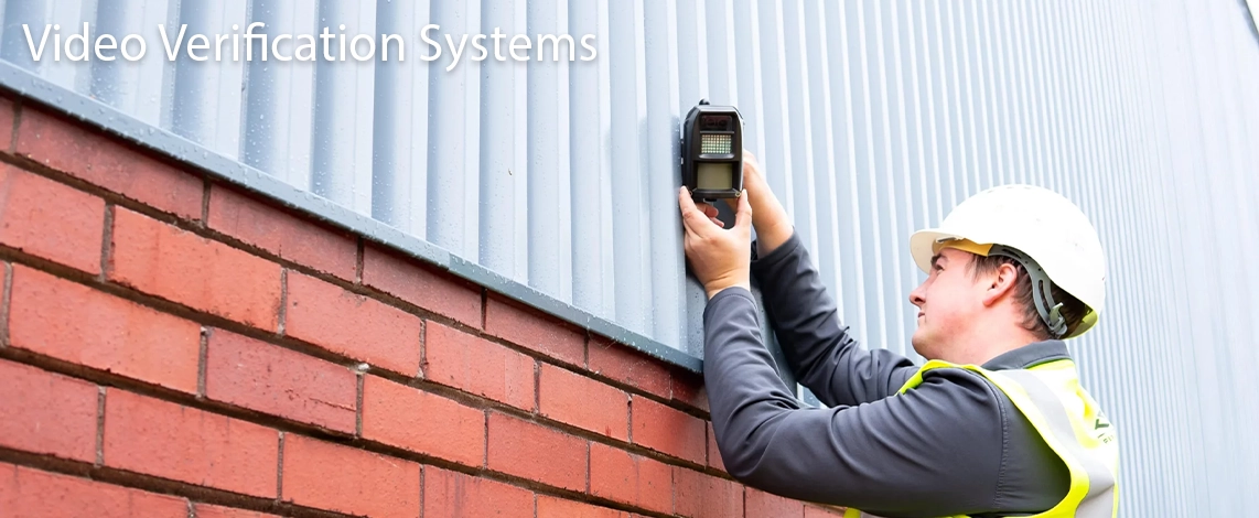 A D-TECT engineer installing video verification equipment to the exterior of a commercial building